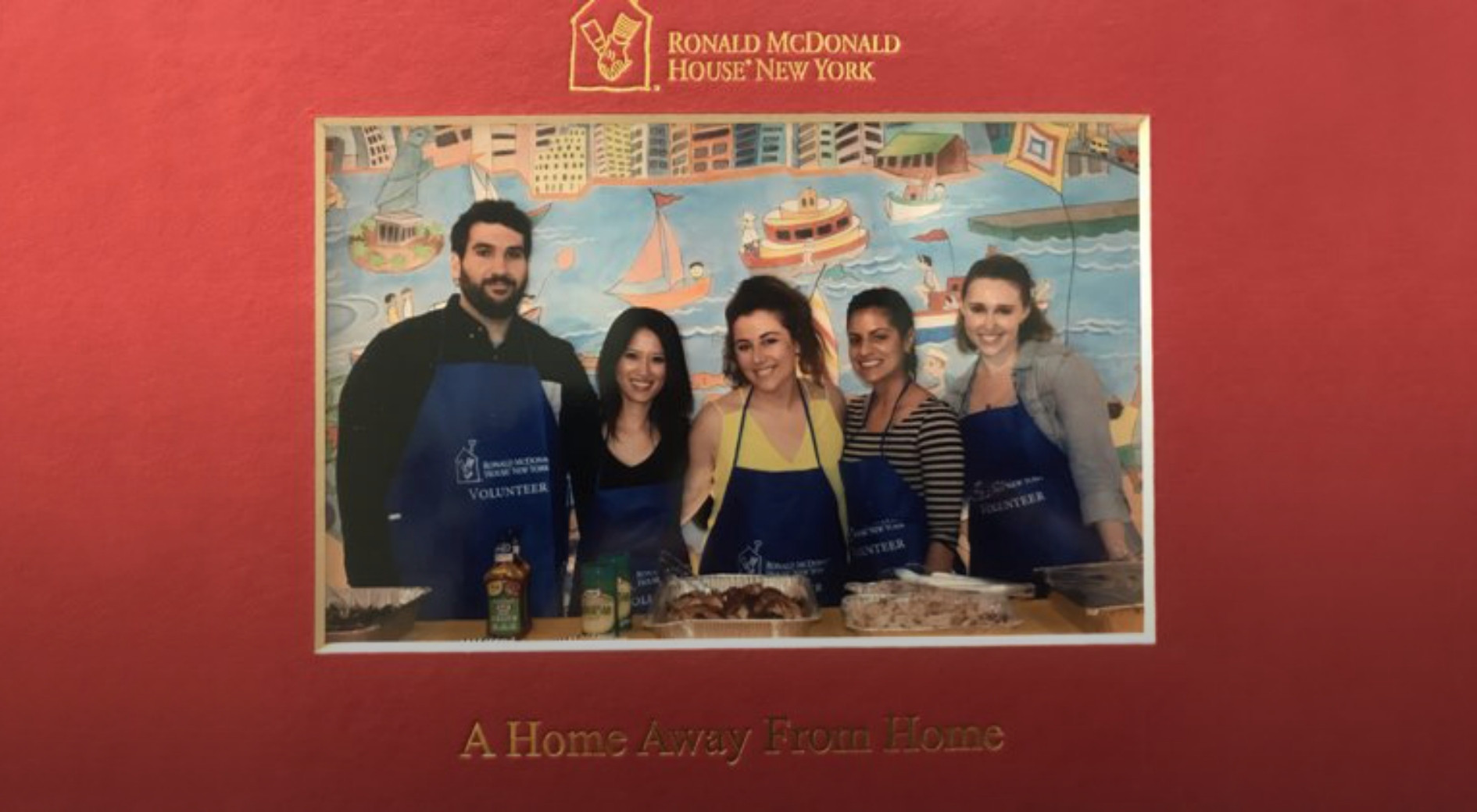An image of five smiling adults standing next to each other. In front of them is a cooked dinner and the text 